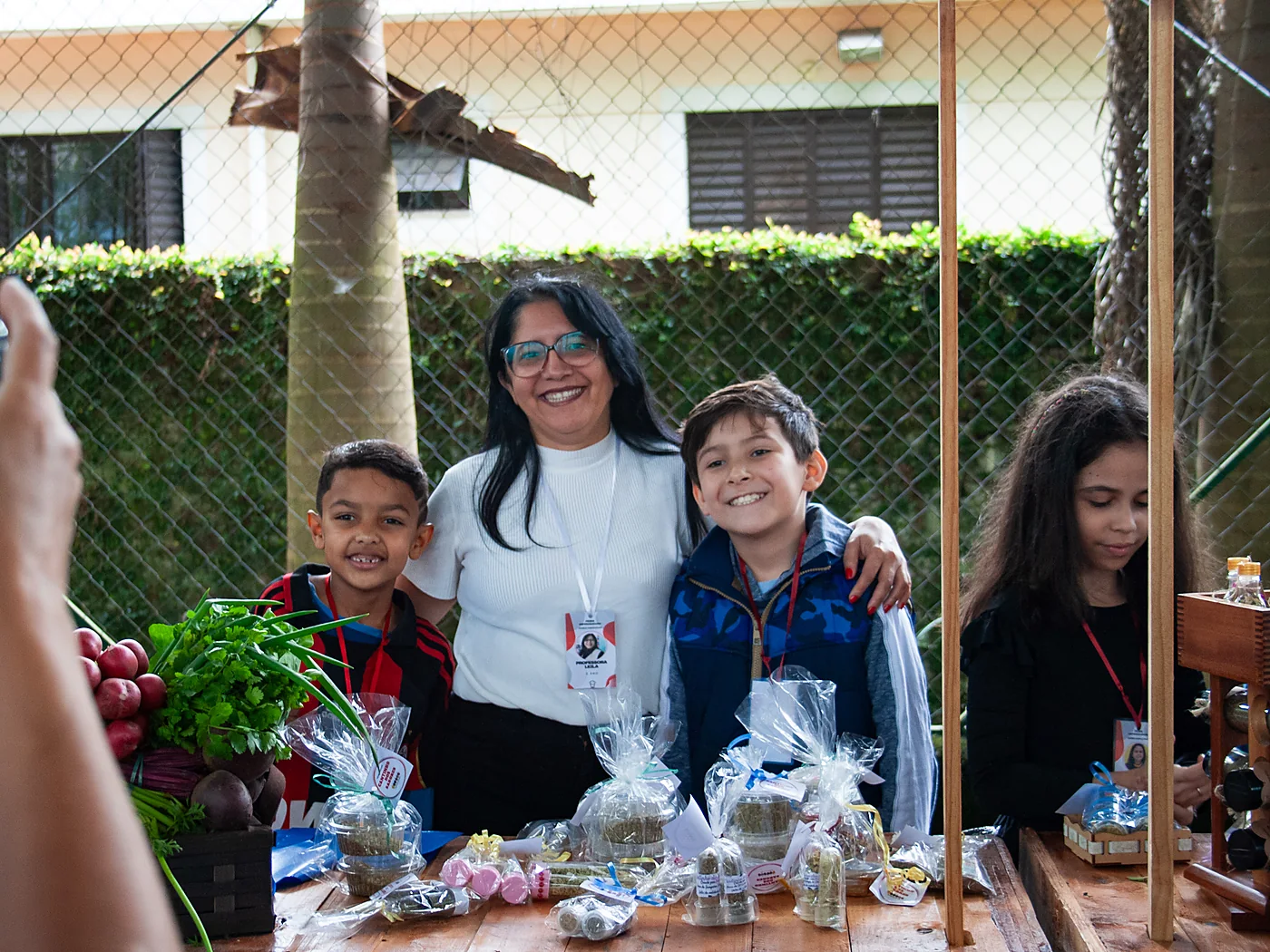 Professora e crianças atendendo na Feira Empreendedora