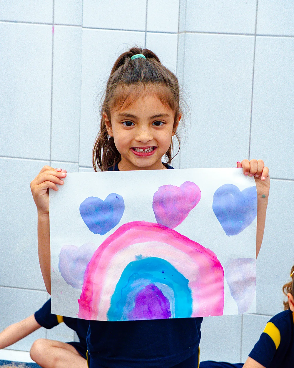 Criança da Educação Infantil mostrando um desenho no Colégio Campos Piaget
